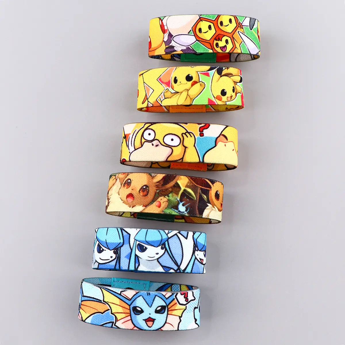 A set of six colorful cartoon-themed stretch wristband bracelets made of silicone featuring various Pokémon characters like Pikachu and Eevee in vibrant playful designs.