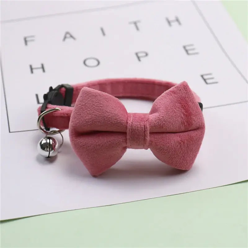 Ein weiches rosa Samt-Schleifen-Katzenhalsband mit einem silbernen Glöckchen-Anhänger, von einem Samt-Schleifen-Katzenhalsband mit Glöckchen im 3er-Set.