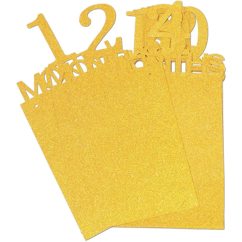 Goldglitzernde Papier-Zahlen-Ausschnitte der Nummern 12 und 40 mit dem Wort „Monate“ in einer dekorativen Schrift, die in einer Fotobanner-Meilenstein-Girlande zum ersten Geburtstag des Babys enthalten sind.