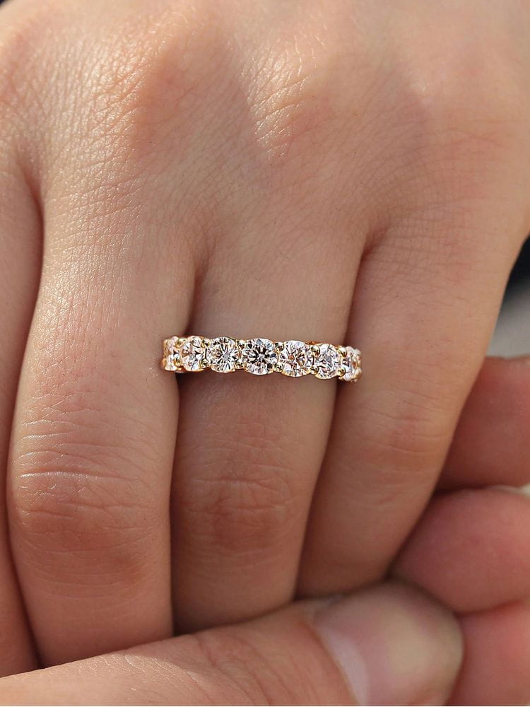 A rose gold eternity band ring featuring a continuous line of round-cut diamonds made of sterling silver zircon wedding band for women.
