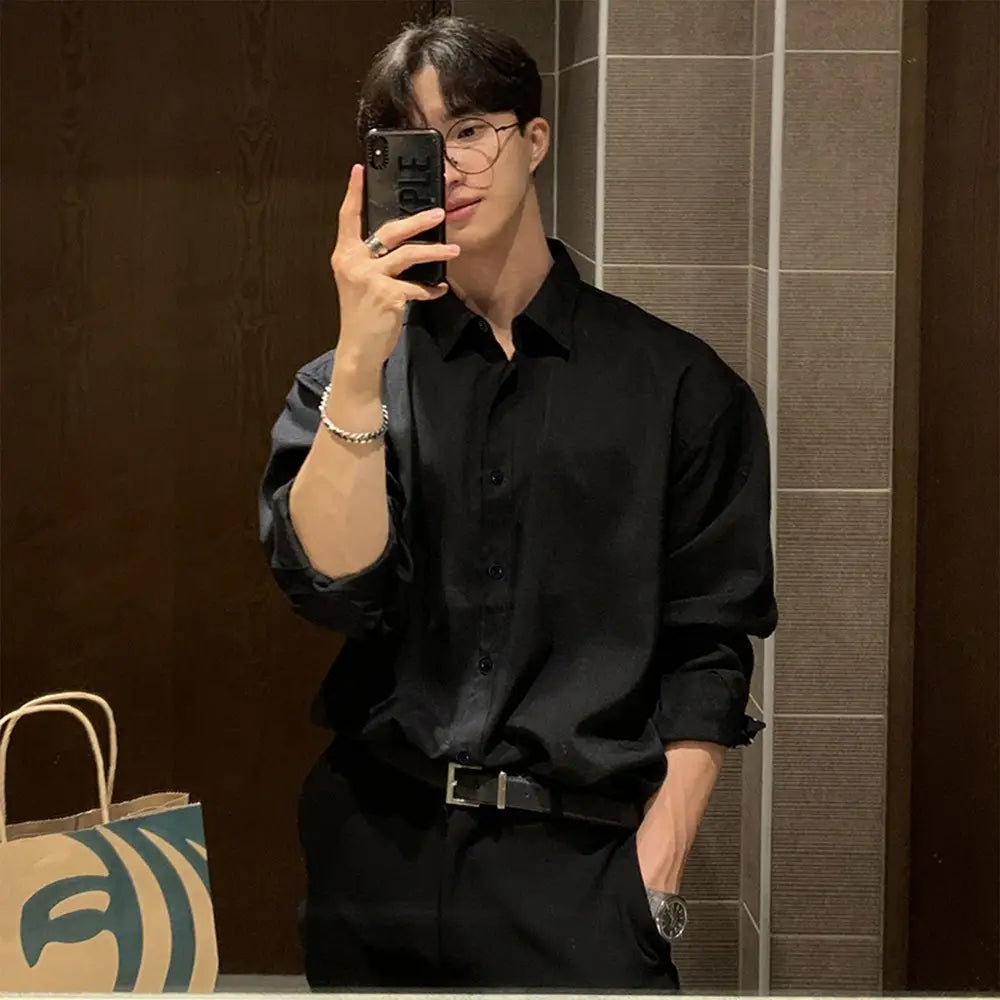 Men black long sleeve casual button down shirt made of soft fabric with rolled sleeves and a classic collar.