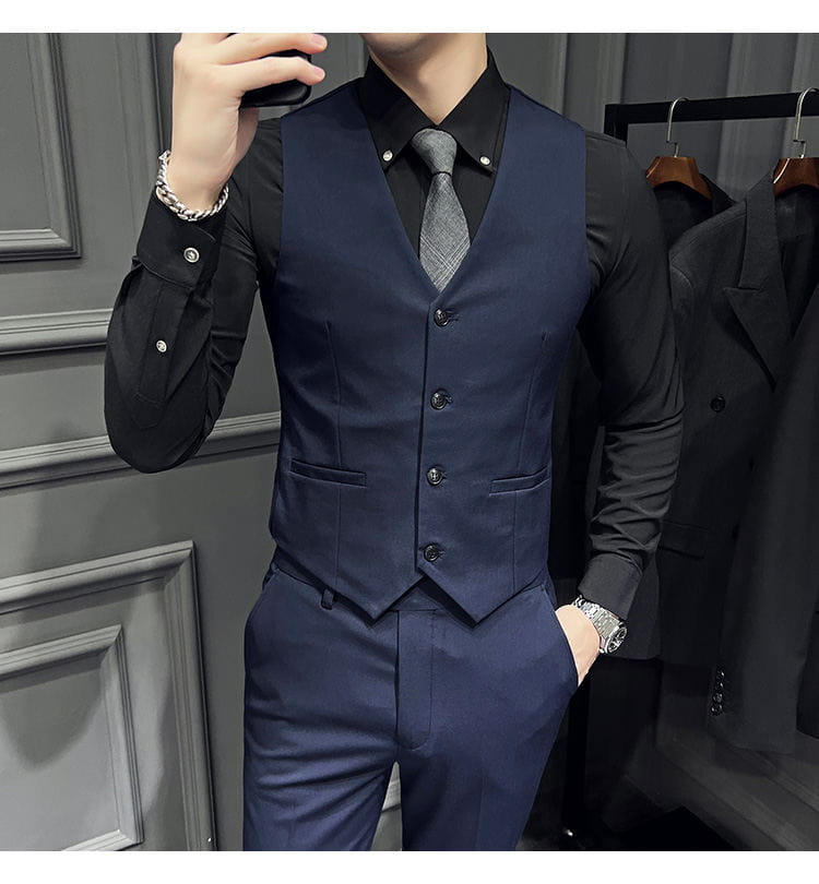 Gilet bleu marine, taillé sur mesure, avec fermeture par bouton noir et poches à rabat, faisant partie d’un ensemble de costume slim fit pour homme avec 9 pantalons courts à la cheville.