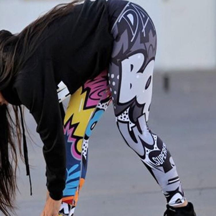 Vibrant high waist graffiti workout leggings featuring bold pink yellow blue and white pop art graphics on a black base for fitness activities.