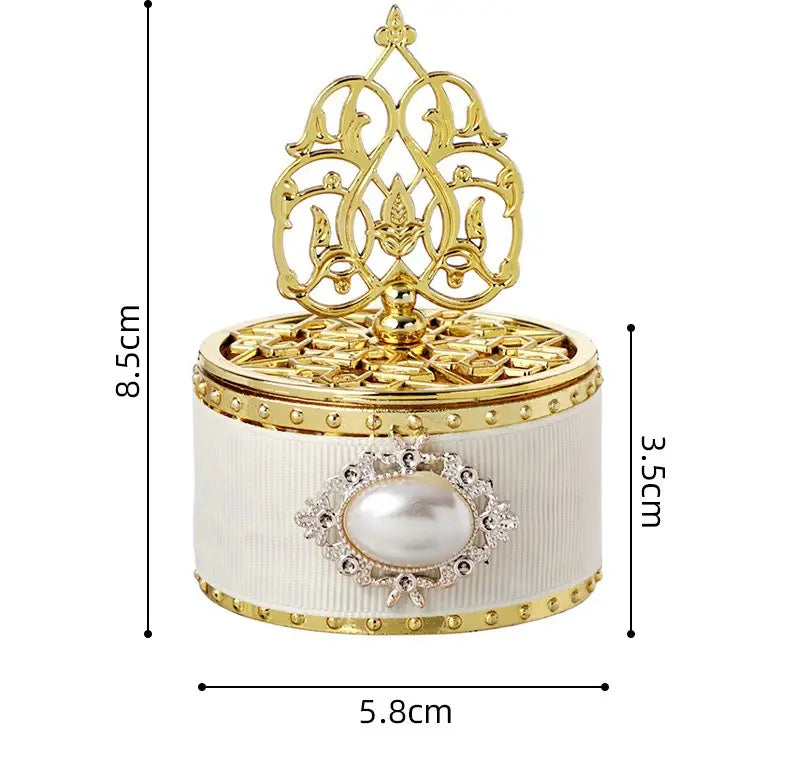 Boîte à bonbons de mariage dorée élégante blanche cannelée avec bordure dorée, avec une perle centrale rehaussée de cristaux étincelants et un couvercle en filigrane doré orné.