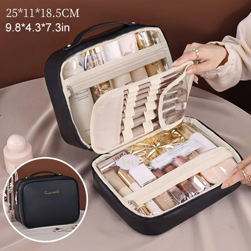Black fabric double layer travel makeup bag with cream-colored interior compartments, transparent pockets, top handle, and beige PU leather accents.
