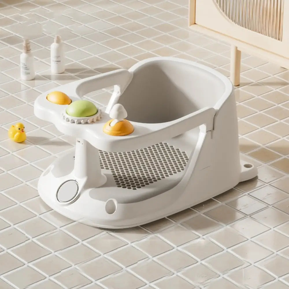 Asiento de baño para bebé de plástico blanco con ventosas y visualizador de temperatura, con juguetes texturizados de color naranja y verde en la bandeja.