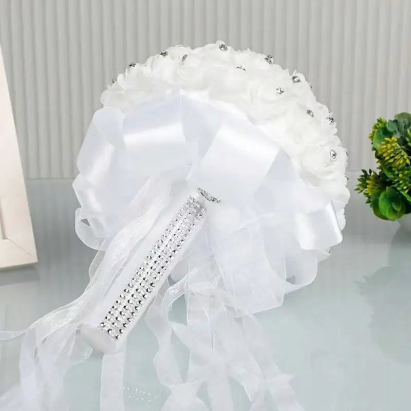 繊細なサテンリボンで飾られた白いラインストーンの結婚指輪リングピローのフローラル・ブライダルブーケ。