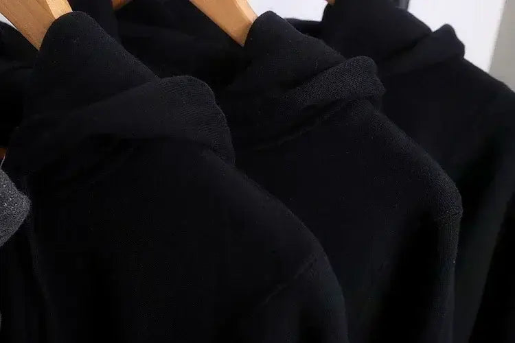 Oversized v back graphic hoodie streetwear pullover in black fleece with soft plush texture and ribbed cuffs shown from the back side.