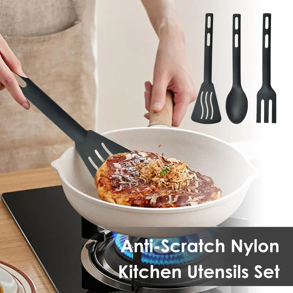 black anti-scratch nylon spatula with wooden handle from camping kitchen utensils set nylon cookware flipping a pancake in a white frying pan