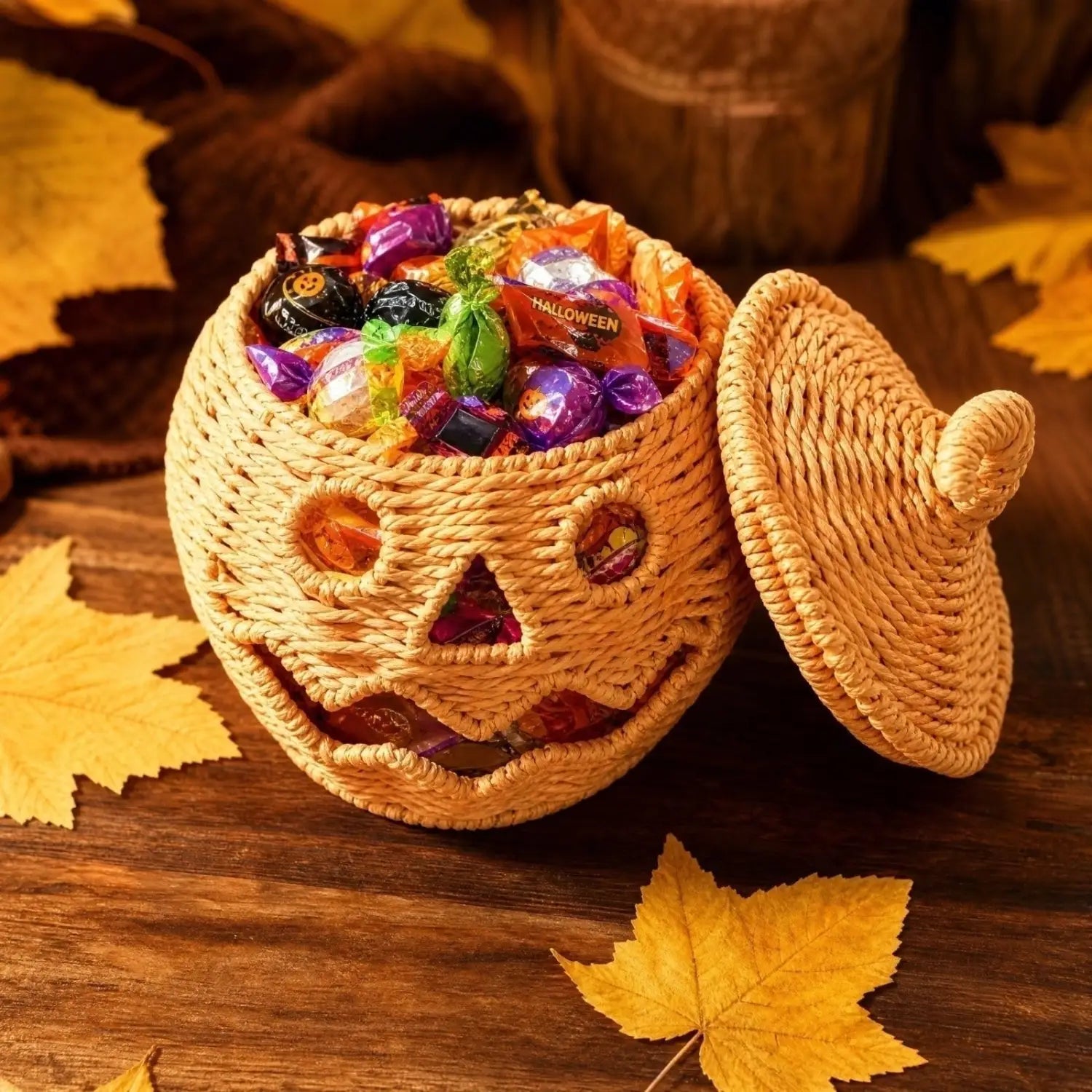 Geflochtene Kürbislaterne mit Hexenhut geformtem Candy-Glas in Orange, mit geschnitzten Gesichtszügen und gefüllt mit farbenfrohen Halloween-Süßigkeiten.