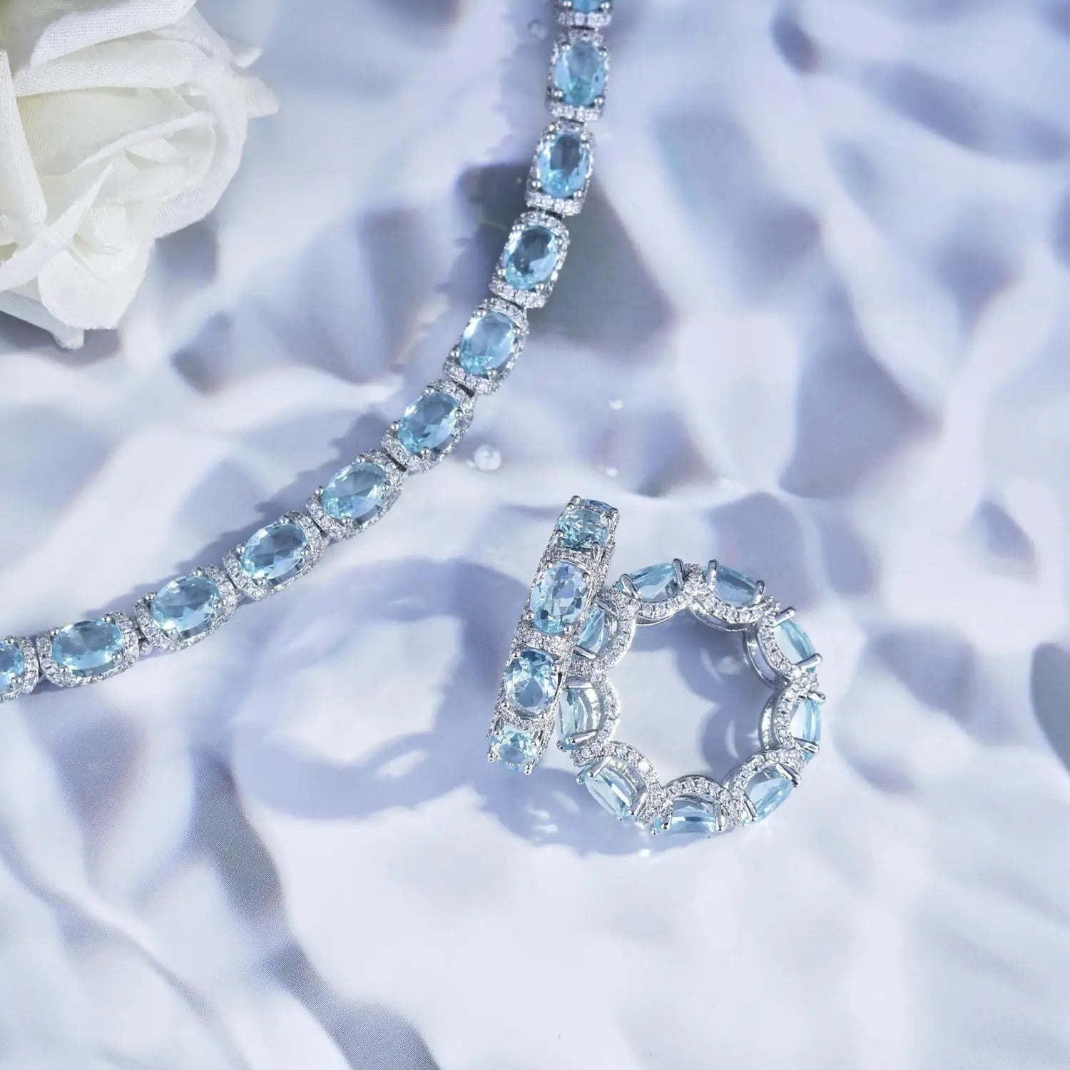 Elegant aquamarine crystal bridal jewelry set featuring a silver-toned bracelet and matching ring with oval-cut blue topaz and diamond stones.