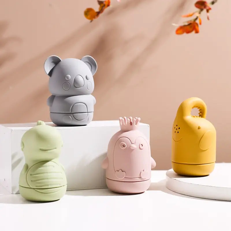 Pastellrosa Pinguin-förmiges Silikon-Baby-Badesprinkler-Spielzeug mit Kronendetail, entwickelt für sicheres und unterhaltsames Wasserspiel.