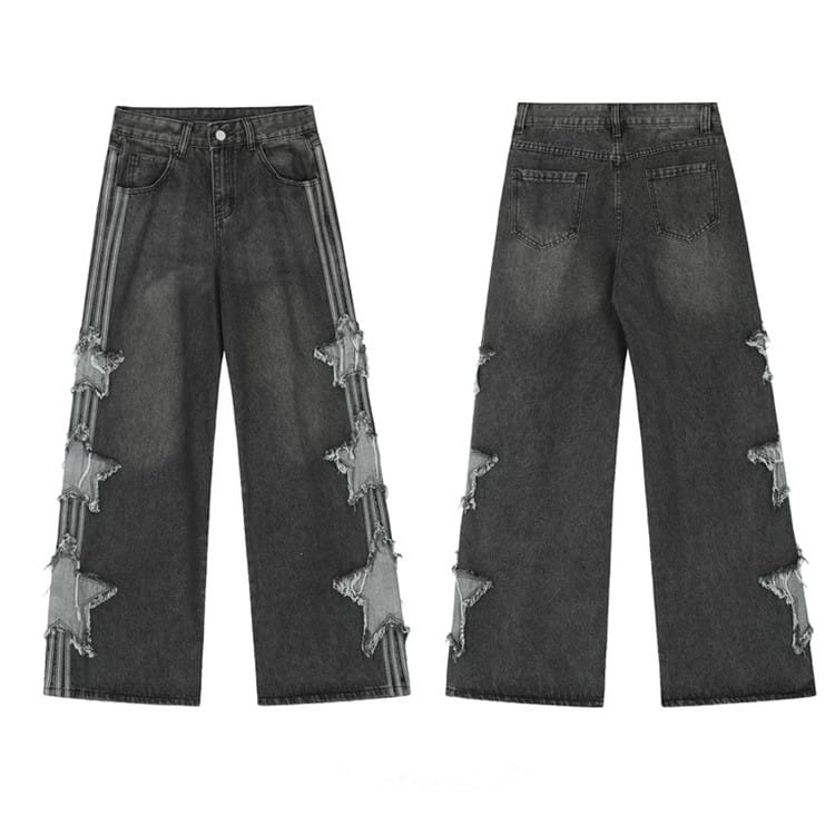 Jeans en denim délavé et déchiré gris foncé style Y2k baggy, avec patchs en forme d’étoiles et détails rayés verticaux le long de la jambe extérieure.
