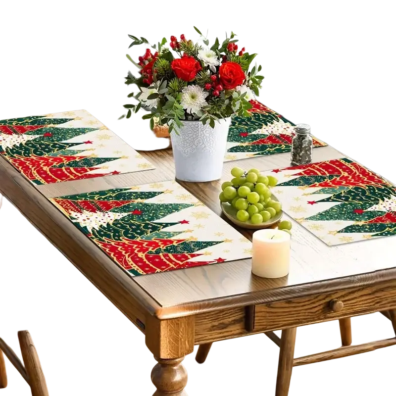 Linen christmas tree placemats with red and green pine patterns on white background arranged on wooden dining table