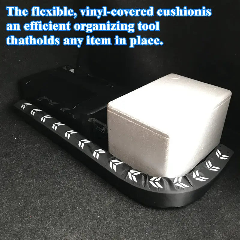 Black vinyl-covered car trunk organizer cushion with white leaf-like patterns along the edge designed for flexible anti-collision stick to hold items securely in place.