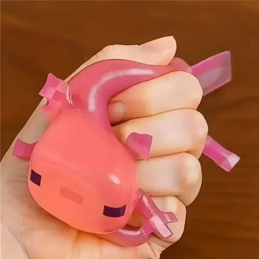 Jouet à mâcher et à malaxer en forme d’axolotl rose, conçu pour soulager le stress, texture souple et molle, avec un corps en plastique brillant translucide et des yeux pixelisés violets, conçu pour apaiser le stress lié au jouet et pour soulager le stress.