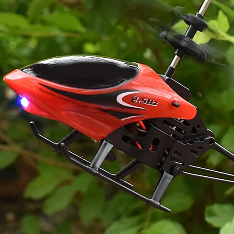 Red and black remote control helicopter with a glowing blue LED light on its nose in a remote control aircraft toy package includes features for enhanced night flying.