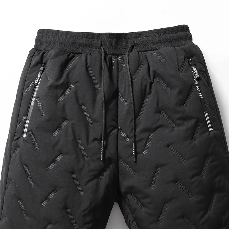 Men fleece lined thermal sweatpants in black quilted fabric with a zigzag pattern and side pockets featuring zipper pulls labeled new sports.