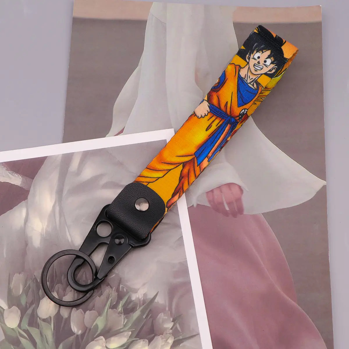 A vibrant orange and blue fabric Dragon Ball Z Goku keychain strap featuring a printed anime character design.