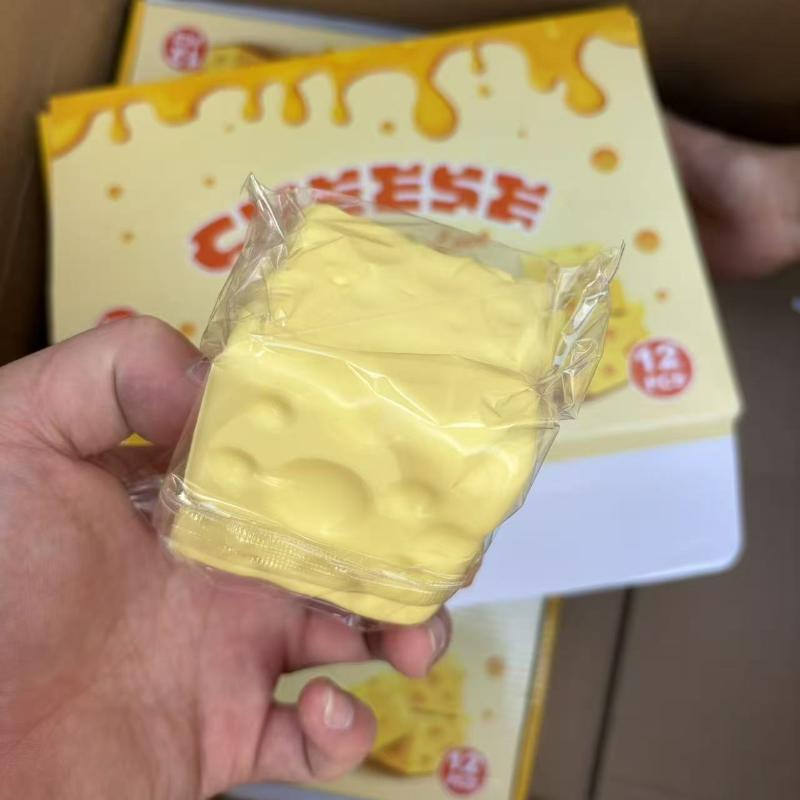 a yellow square-shaped cheese-themed fidget toy measuring 6cm × 6cm with molded holes and a glossy plastic wrapper designed for stress relief