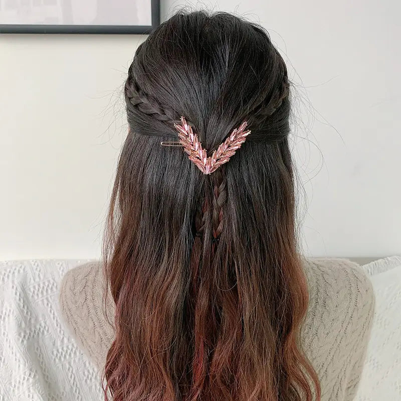 Rose gold wheat-themed crystal v shape hair clip holding dark brown ombre braided hair.