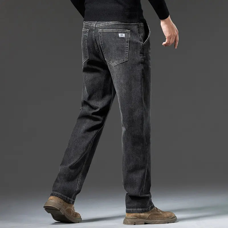 Jeans rétro délavés coupe droite ample pour hommes en denim gris foncé foncé, montrés depuis l’arrière, avec une coupe droite, une décoloration subtile, des surpiqûres classiques et un petit empiècement de marque sur la poche arrière.