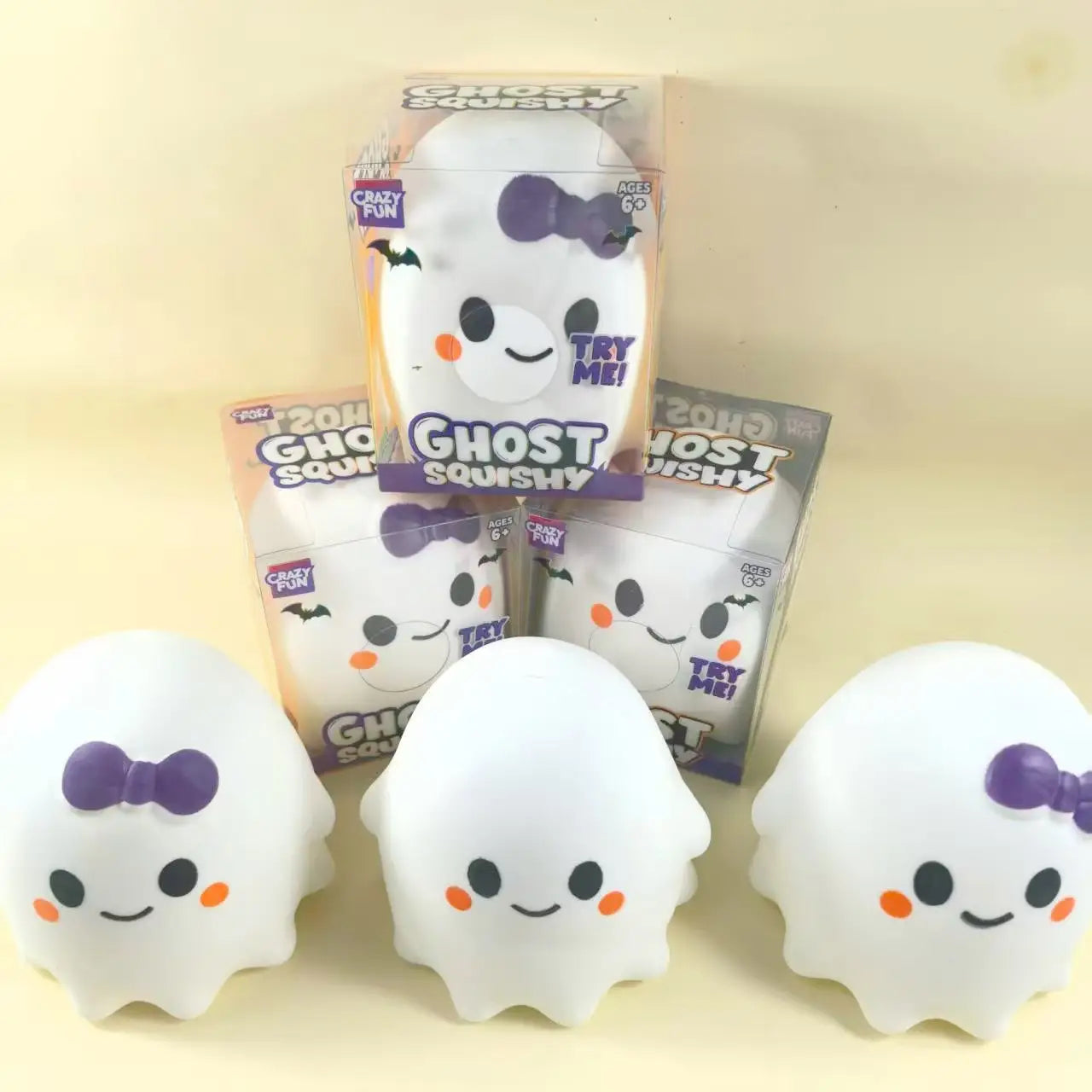 White ghost-shaped slow rising stress relief squishy toys with purple bows and orange cheeks packaged in clear plastic boxes labeled ghost squishy by Crazy Fun.