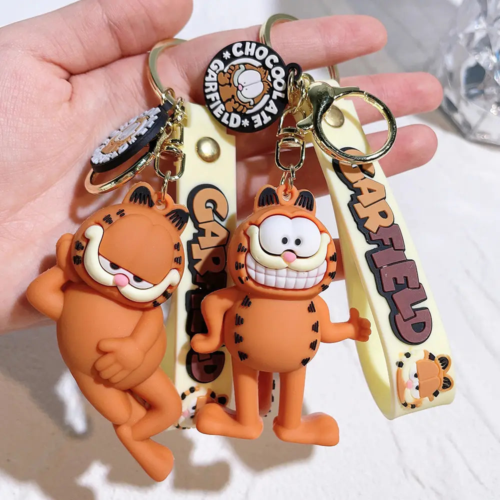 orange garfield keychains made of rubber featuring black stripes white accents and smiling and angry facial expressions as anime cat key pendants.