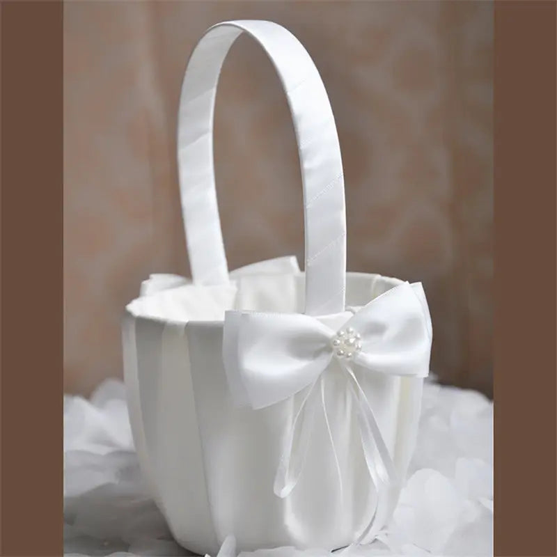 Panier de demoiselle d’honneur en satin blanc, orné d’un nœud agrémenté de perles, conçu pour les cérémonies de mariage.