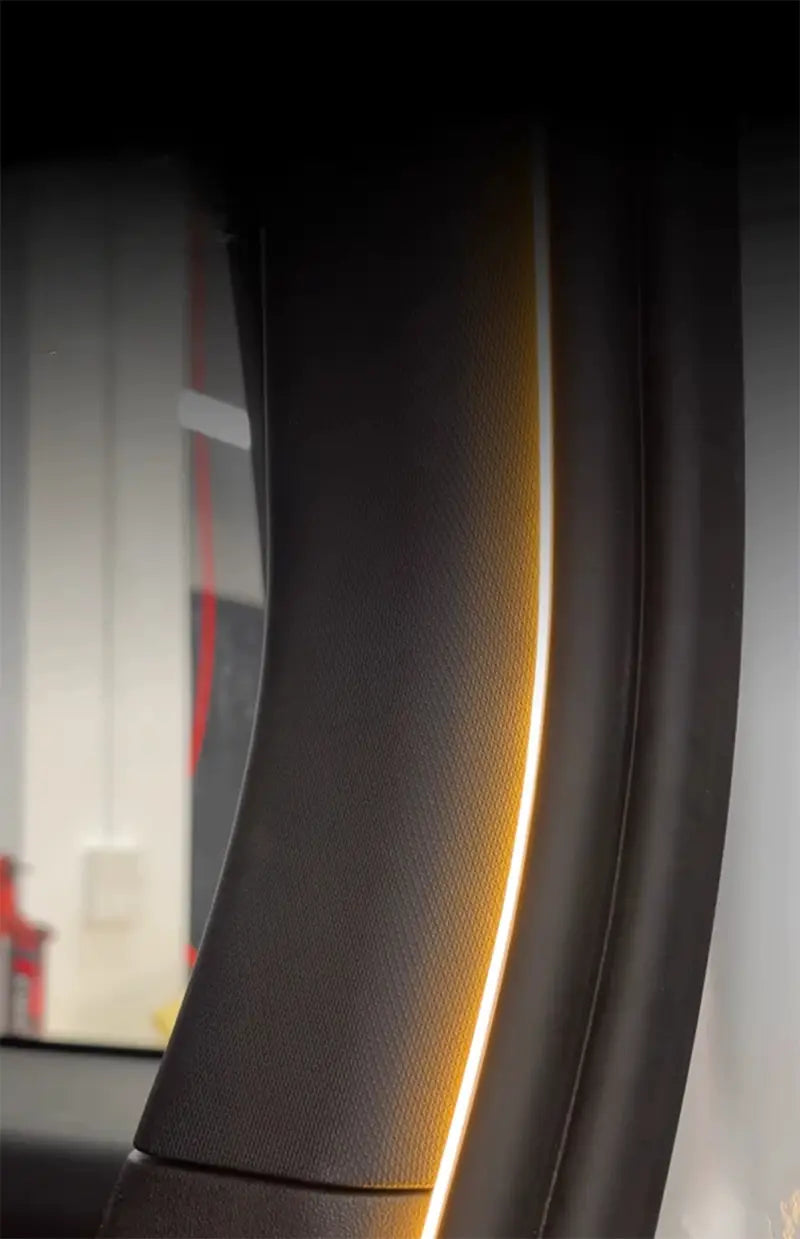 Black textured steering wheel with glowing amber accent light along its curved edge featured in car trunk lighting baic 212 t01 2024 for modified auto trunk and trunk lighting fit applications.