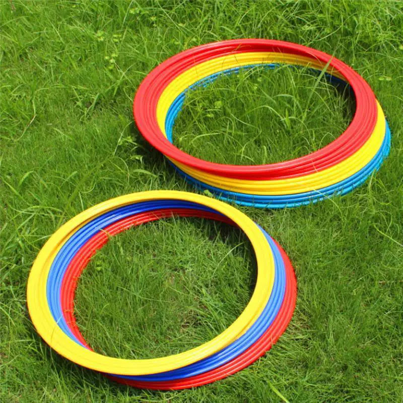 Stacked brightly colored plastic agility training rings in red yellow and blue for soccer speed exercise equipment.
