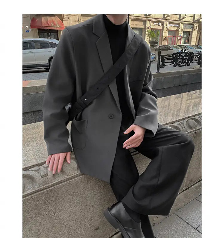Blazer de doble botonadura oversize para hombre en poliéster gris oscuro, casual, con ajuste estructurado pero relajado, solapas tipo pico y dos bolsillos frontales.