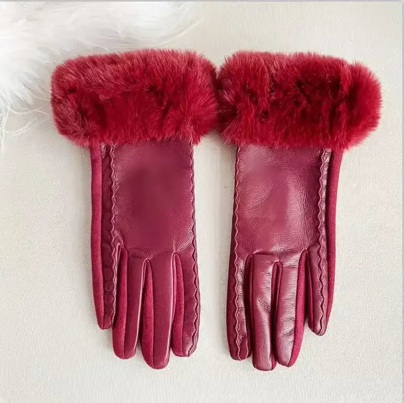 A pair of women’s fur-lined winter leather gloves in burgundy featuring plush red fur cuffs and decorative stitching along the edges.