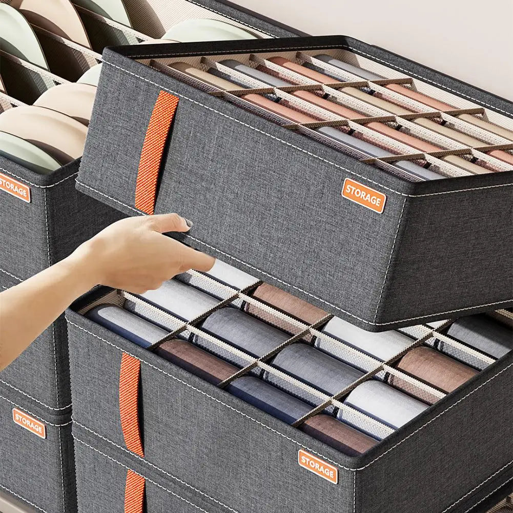 Dunkelgraue Stoff-Schubladenorganizer-Box mit orangefarbenem Riemen und Aufbewahrungsschild, ausgelegt für das ordentliche Verstauen gefalteter Socken und Unterwäsche.