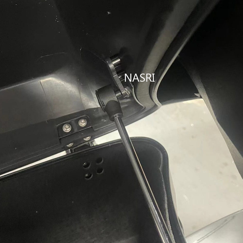 Black metal gas strut with rubberized grip attached to a vehicle door hinge mechanism for Harley touring trunk support rod 2014-2023.