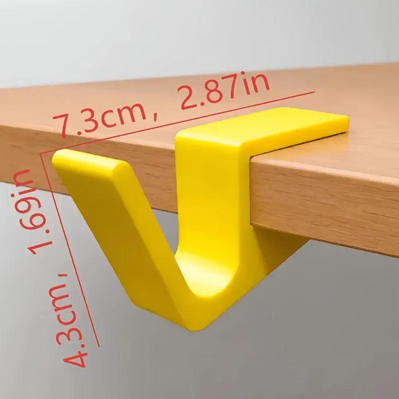 bright yellow plastic desk edge bag hook with a v-shaped design for holding backpacks securely
