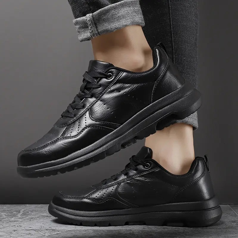 Men black leather chunky sole sneakers featuring a sleek minimalist design and sturdy rubber soles.