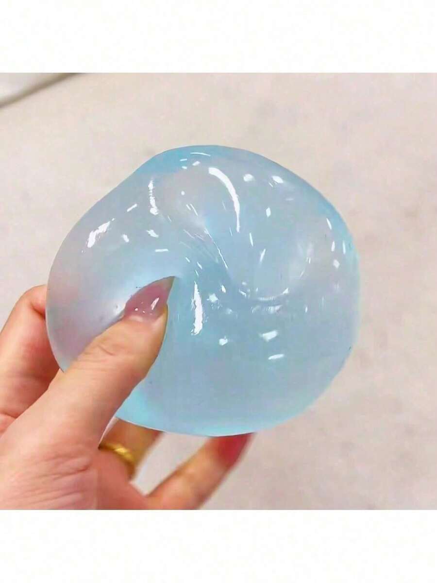 Une balle compressible antistress translucide bleu clair à base de gel, à texture brillante, avec des tourbillons internes subtils.