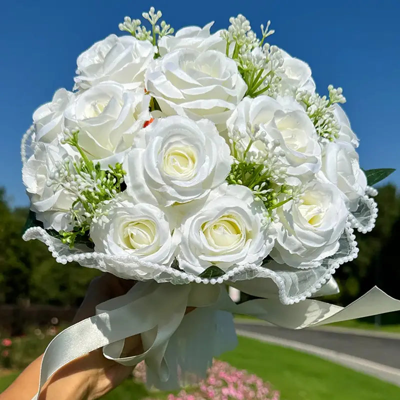 white silk rose wedding bouquet featuring delicate artificial white roses with lace trim satin ribbon and small greenery accents