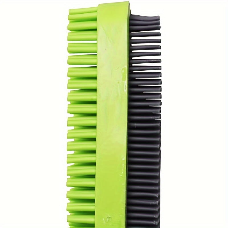 A dual-sided silicone pet hair remover brush with bright green and black bristles and a sturdy plastic handle.