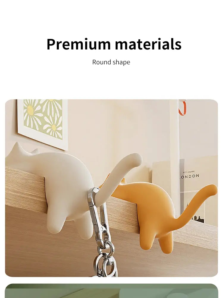 Cream and orange silicone cat desk hook silicone organizers with metal chain attachments for keychain holding.