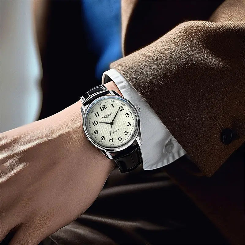 A sleek silver-toned mens quartz leather watch with a cream-colored dial, classic arabic numerals, black leather strap, and waterproof feature suitable for business use.