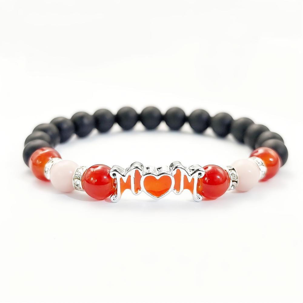 Pulsera para madre con cuentas rojas y negras con brillo en la oscuridad, con un dije plateado para mamá con un corazón naranja en el centro, diseñada como joyería de regalo para mamá.