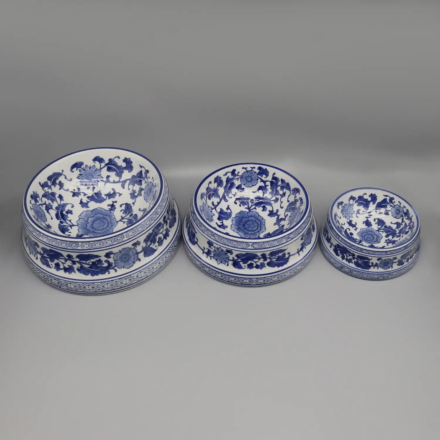Three blue and white porcelain feeding bowl ceramic set with intricate floral patterns arranged in descending size.