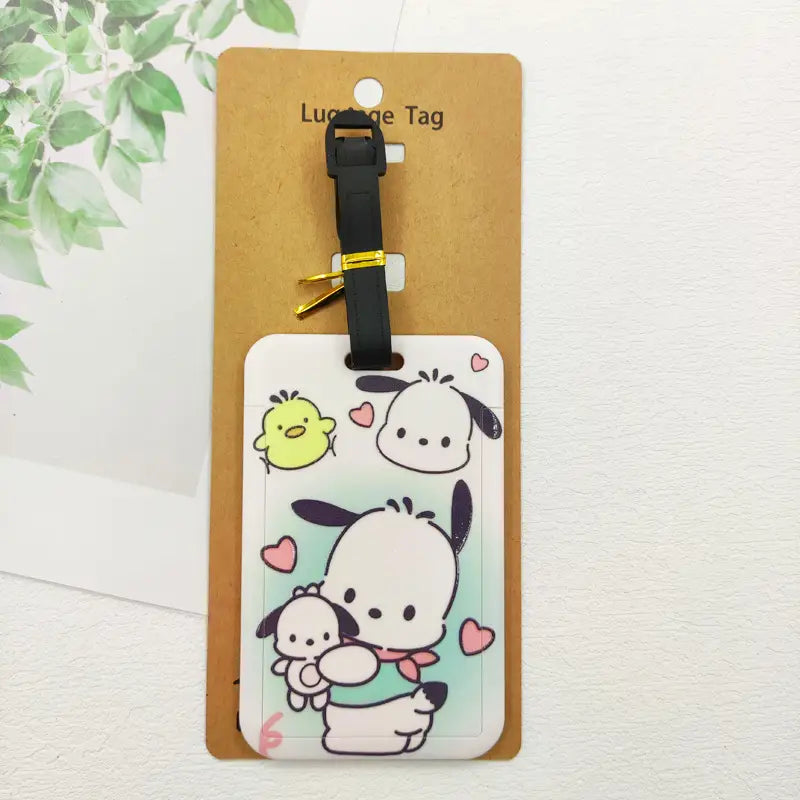 Étiquette de bagage rectangulaire blanche Hello Kitty, avec des personnages de dessin animé, une sangle noire et une boucle de couleur dorée pour l’identification de la valise.