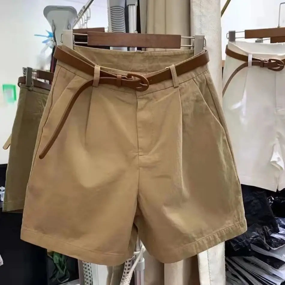 Beige wide leg women casual summer shorts with pleats and a matching brown leather belt.