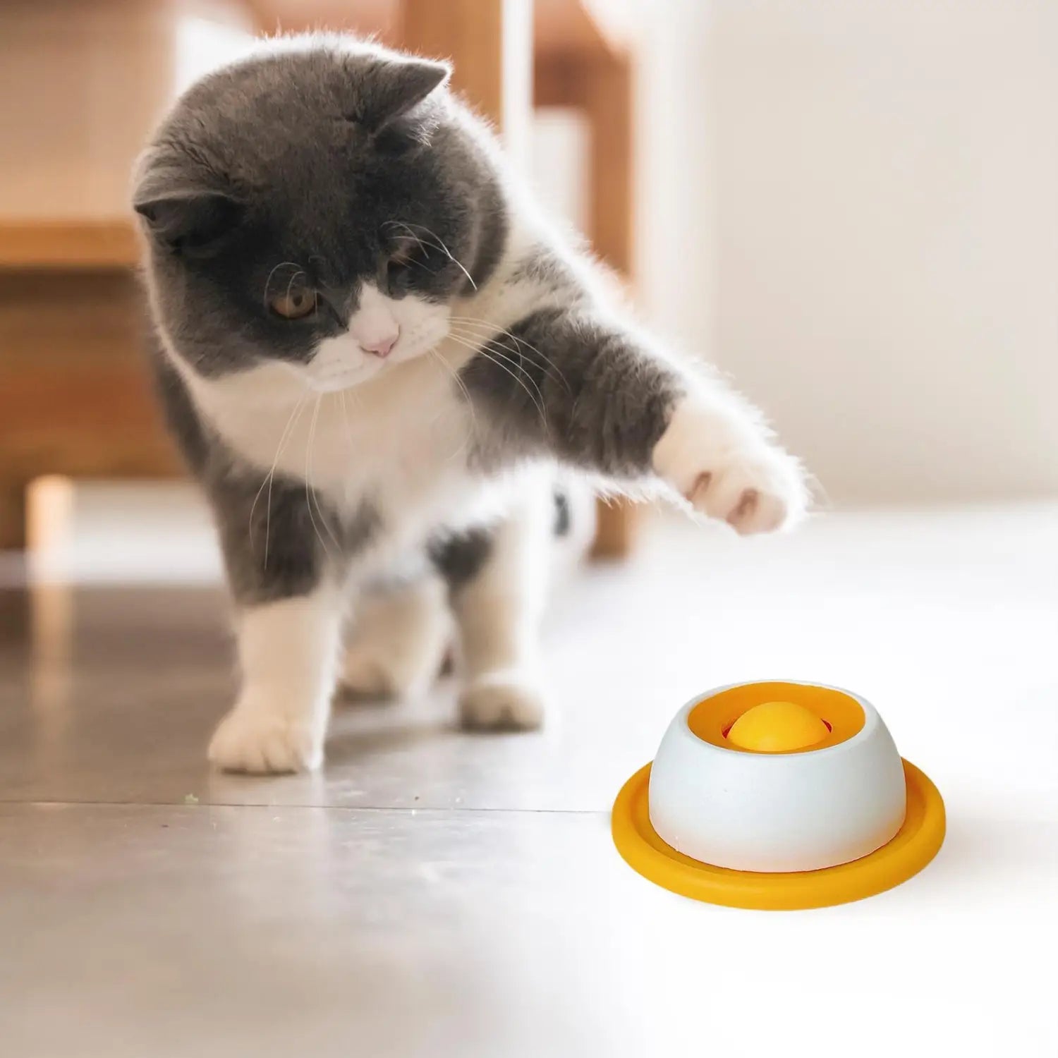 A bright yellow and white interactive dog licking toy slow feeder puzzle for puppies with a round bowl shape and a central orange ball.