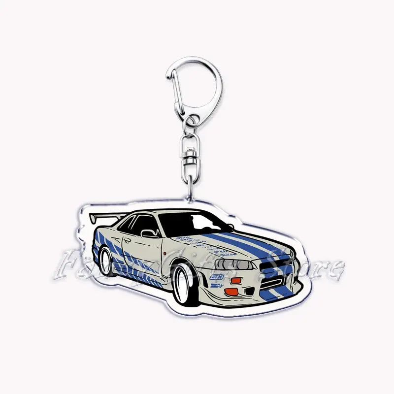 Clear acrylic keychain featuring a white and blue striped Nissan Skyline R34 with racing decals for car enthusiasts.