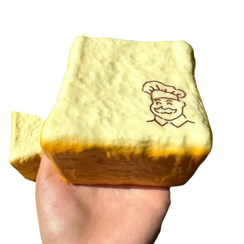 A soft pale yellow bread-shaped foam fidget toy with slow rising texture and smiling chef design suitable for universal age range