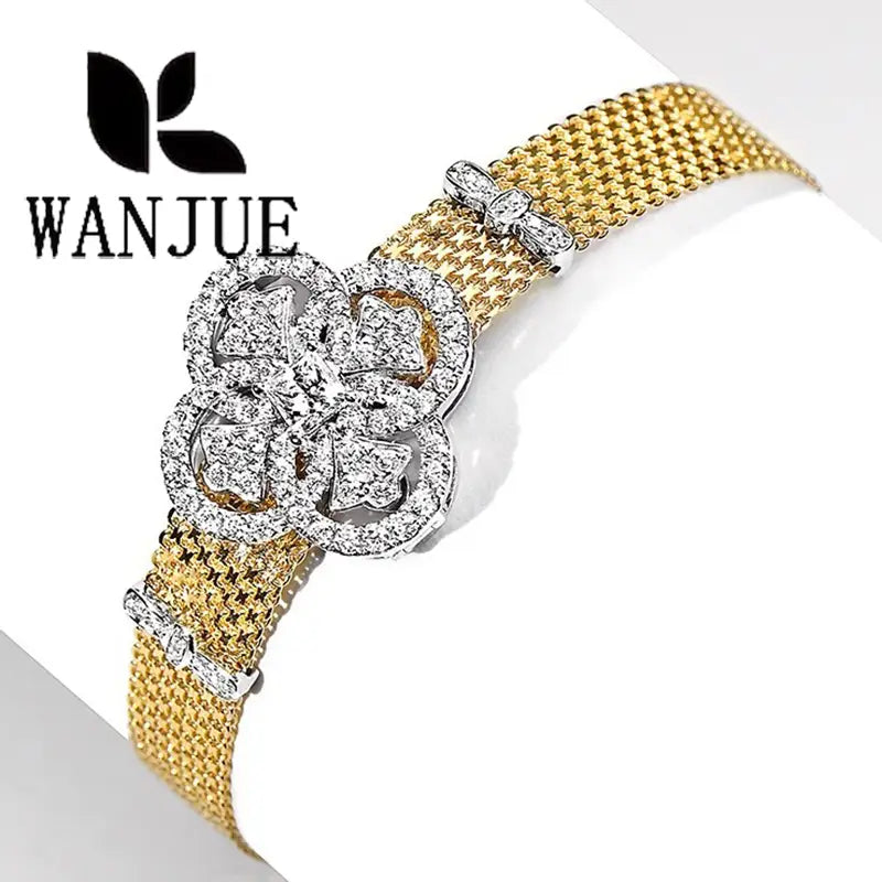 Crystal flower gold mesh cuff bracelet featuring a gold mesh band with a sparkling silver four-leaf clover clasp adorned with clear crystals.